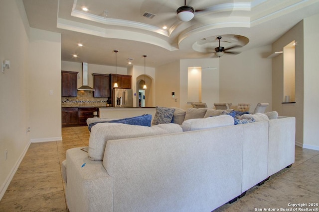 3915 Bacall, Converse, TX 78109 - living room with ceiling fan, a raised ceiling, recessed lighting, ornamental molding, and arched walkways