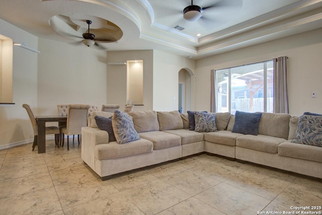 3915 Bacall, Converse, TX 78109 - living room featuring a ceiling fan, a tray ceiling, arched walkways, and light tile patterned floors