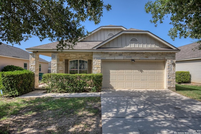 5715 Sendero Spg, San Antonio, TX 78251 - view of front of house with board and batten siding, stone siding, a garage, driveway, and roof with shingles