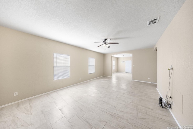 5715 Sendero Spg, San Antonio, TX 78251 - empty room with ceiling fan, arched walkways, and a textured ceiling