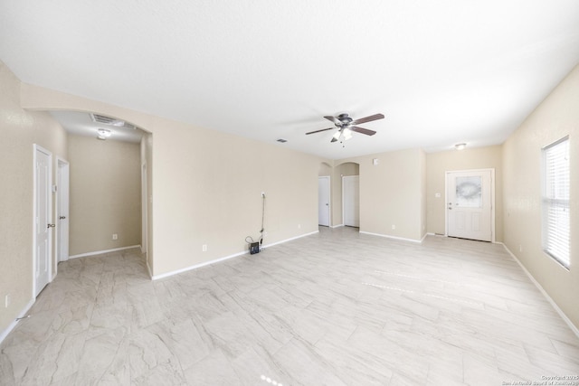 5715 Sendero Spg, San Antonio, TX 78251 - unfurnished living room featuring arched walkways, a ceiling fan, and light marble finish floors