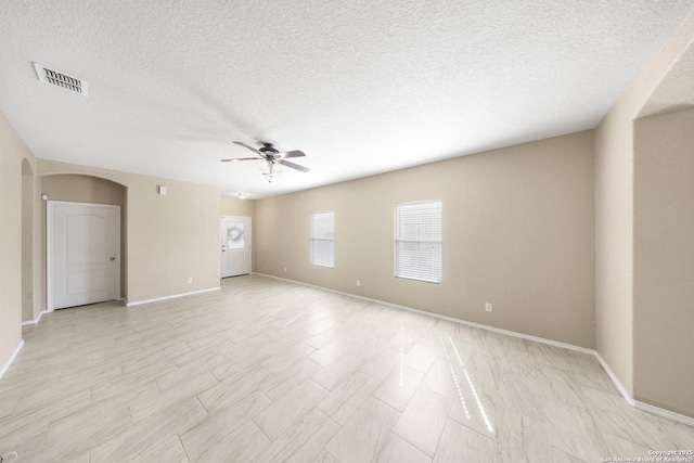 5715 Sendero Spg, San Antonio, TX 78251 - empty room with arched walkways, a ceiling fan, and a textured ceiling