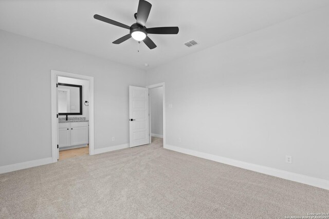 159 Azalea Aly, Castroville, TX 78009 - unfurnished bedroom with light colored carpet, ensuite bathroom, and ceiling fan