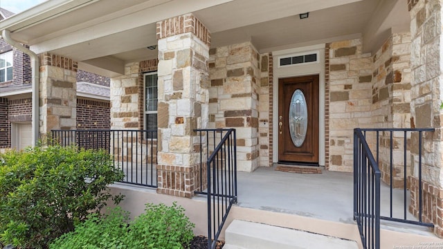 12618 Ozona Rnch, San Antonio, TX 78245 - view of exterior entry with stone siding, a porch, and brick siding