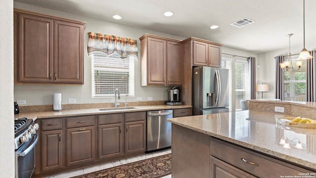 12618 Ozona Rnch, San Antonio, TX 78245 - kitchen featuring stainless steel appliances, a chandelier, light stone countertops, hanging light fixtures, and recessed lighting