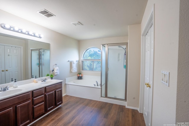 9534 Anderson Way, Converse, TX 78109 - full bathroom featuring wood finished floors, a stall shower, double vanity, and a bath