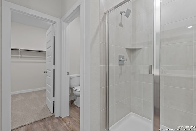 9962 Forestier Grn, San Antonio, TX 78214 - full bath with a walk in closet, a shower stall, and wood finished floors