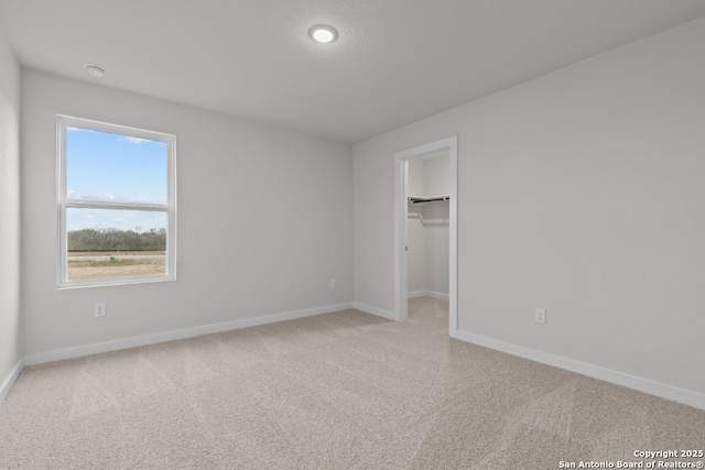 9962 Forestier Grn, San Antonio, TX 78214 - unfurnished bedroom with light colored carpet, a spacious closet, and recessed lighting