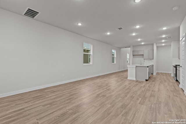 9962 Forestier Grn, San Antonio, TX 78214 - unfurnished living room featuring light wood-style flooring and recessed lighting