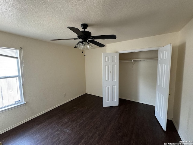 6547 Estes Flts, San Antonio, TX 78242 - unfurnished bedroom with wood finished floors, multiple windows, a textured ceiling, a closet, and a ceiling fan
