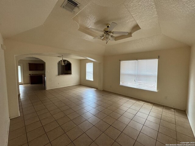 6547 Estes Flts, San Antonio, TX 78242 - unfurnished room with arched walkways, a ceiling fan, tile patterned floors, a textured ceiling, and a raised ceiling