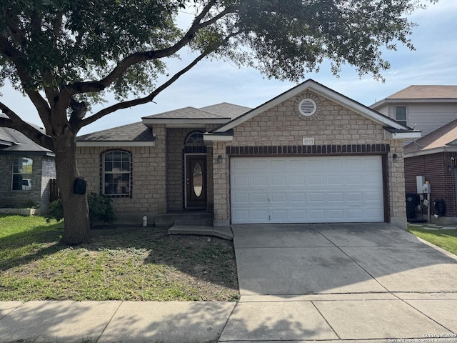 6547 Estes Flts, San Antonio, TX 78242 - view of front of home with an attached garage, concrete driveway, stone siding, and roof with shingles
