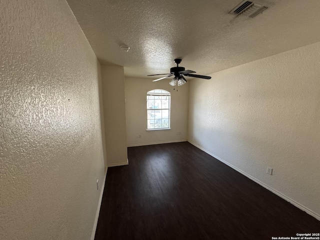 6547 Estes Flts, San Antonio, TX 78242 - spare room featuring a textured wall, dark wood-style floors, ceiling fan, and a textured ceiling