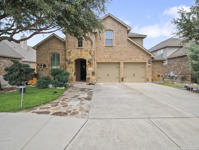 18418 Gran Mesa, San Antonio, TX 78259 - view of front of house featuring driveway, brick siding, a front lawn, an attached garage, and stone siding