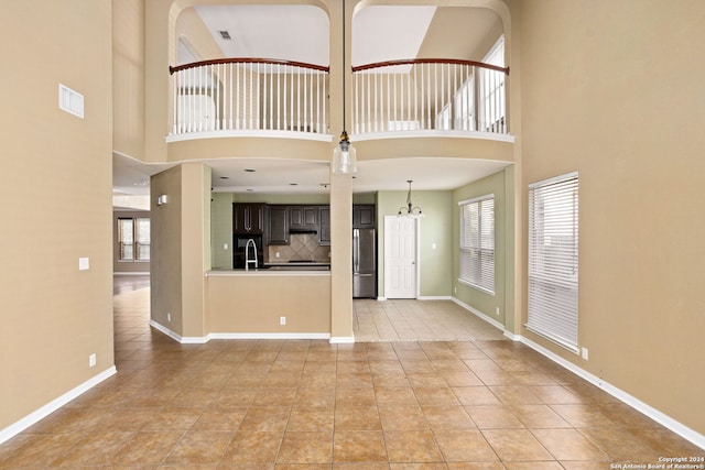 3415 Highline, San Antonio, TX 78261 - unfurnished living room featuring a high ceiling, light tile patterned floors, and a chandelier