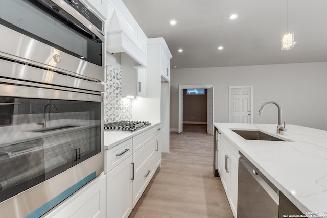 455 S Hackberry, New Braunfels, TX 78130 - kitchen with stainless steel appliances, light wood-type flooring, white cabinetry, decorative light fixtures, and tasteful backsplash