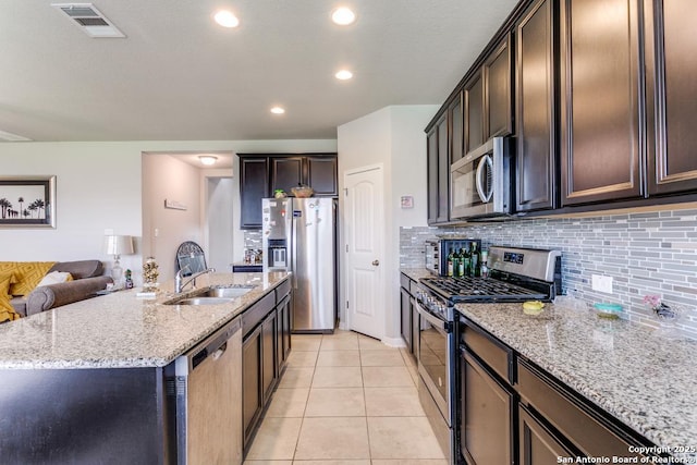 6723 Dashmoor, San Antonio, TX 78244 - kitchen with stainless steel appliances, light stone countertops, tasteful backsplash, dark brown cabinets, and light tile patterned floors