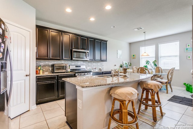 6723 Dashmoor, San Antonio, TX 78244 - kitchen featuring stainless steel appliances, light tile patterned floors, decorative backsplash, light stone countertops, and a kitchen bar
