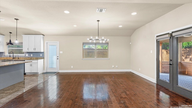 1069 Ivy Ln, Terrell Hills, TX 78209 - kitchen featuring light stone countertops, french doors, white cabinetry, hanging light fixtures, and dark wood-style floors