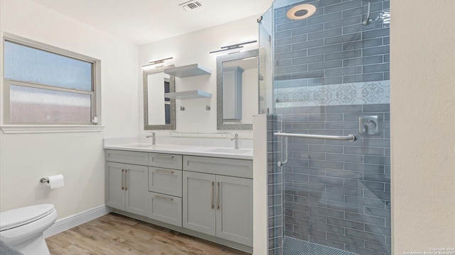 1069 Ivy Ln, Terrell Hills, TX 78209 - bathroom with double vanity, a shower stall, and wood finished floors