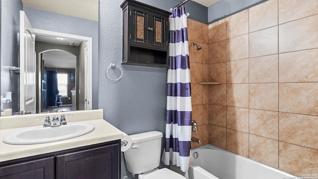 702 Pelican Pt, San Antonio, TX 78221 - bathroom featuring a textured wall, shower / bathtub combination with curtain, and vanity