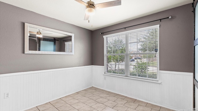 702 Pelican Pt, San Antonio, TX 78221 - unfurnished room featuring a ceiling fan, a wainscoted wall, and healthy amount of natural light
