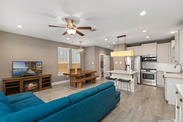 7934 Teak Ln, San Antonio, TX 78209 - living room with light wood-type flooring, ceiling fan, and recessed lighting
