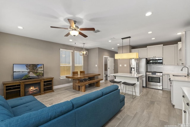 7934 Teak Ln, San Antonio, TX 78209 - living area featuring wood finish floors, a ceiling fan, and recessed lighting