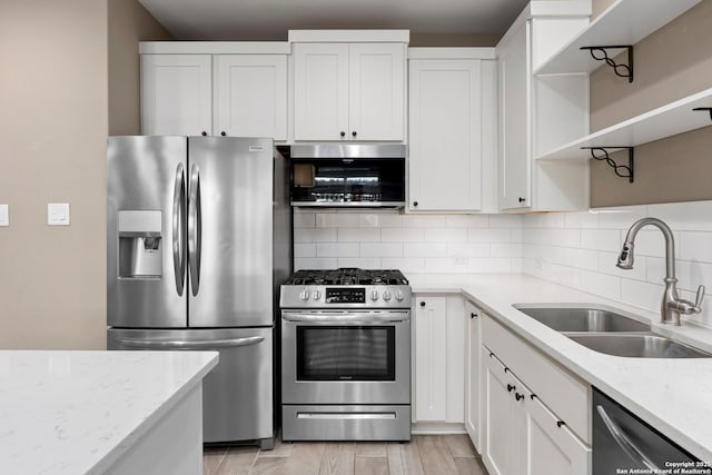 7934 Teak Ln, San Antonio, TX 78209 - kitchen with appliances with stainless steel finishes, open shelves, decorative backsplash, white cabinetry, and light stone counters