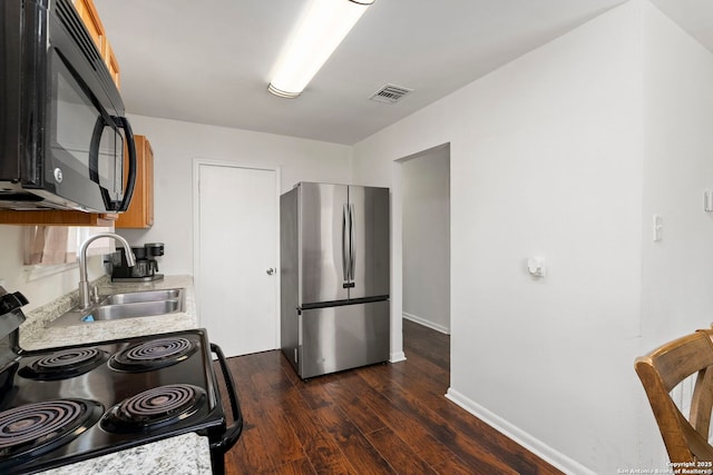 227 Anton Dr, San Antonio, TX 78223 - kitchen featuring freestanding refrigerator, black microwave, range with electric stovetop, light countertops, and dark wood finished floors