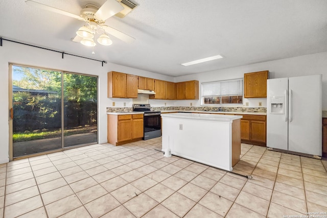 10057 Fall Harvest, San Antonio, TX 78254 - kitchen featuring stainless steel range with electric stovetop, white refrigerator with ice dispenser, light countertops, and brown cabinetry