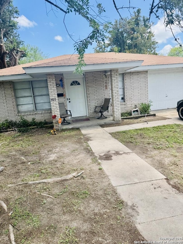 507 W Ireland, Beeville, TX 78102 - view of front of home with brick siding, covered porch, and a garage