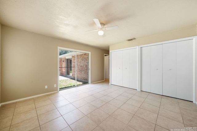 4938 Fairford, San Antonio, TX 78228 - unfurnished bedroom featuring multiple closets, light tile patterned flooring, and ceiling fan