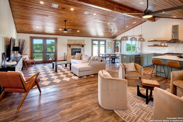 19811 Ranch Road 152, Llano, TX 76831 - living area with ceiling fan, wood ceiling, healthy amount of natural light, wood finished floors, and a stone fireplace