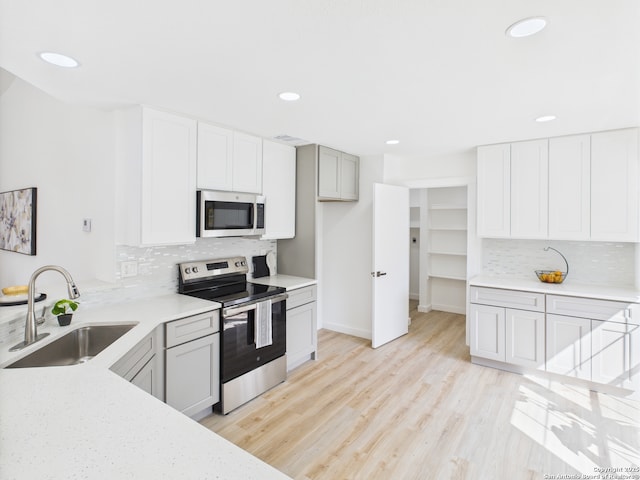 7007 Elk Trl, San Antonio, TX 78244 - kitchen with appliances with stainless steel finishes, tasteful backsplash, recessed lighting, light wood finished floors, and white cabinets