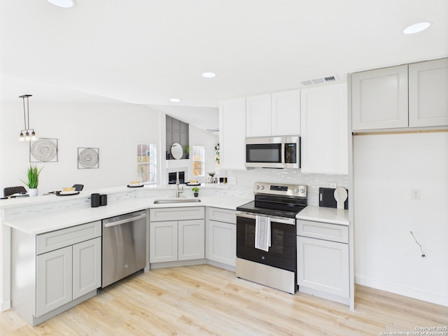 7007 Elk Trl, San Antonio, TX 78244 - kitchen featuring stainless steel appliances, a peninsula, light wood-style flooring, light countertops, and recessed lighting