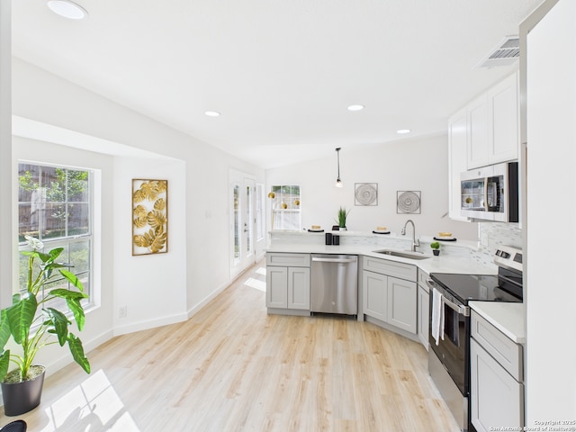 7007 Elk Trl, San Antonio, TX 78244 - kitchen featuring appliances with stainless steel finishes, a peninsula, light wood finished floors, light countertops, and recessed lighting