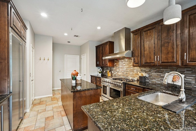 1159 Bluff Frst, San Antonio, TX 78248 - kitchen with wall chimney exhaust hood, double oven range, a kitchen island, decorative backsplash, and stone tile flooring