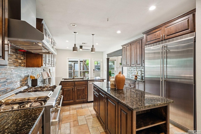 1159 Bluff Frst, San Antonio, TX 78248 - kitchen with stainless steel appliances, wall chimney range hood, open shelves, tasteful backsplash, and recessed lighting