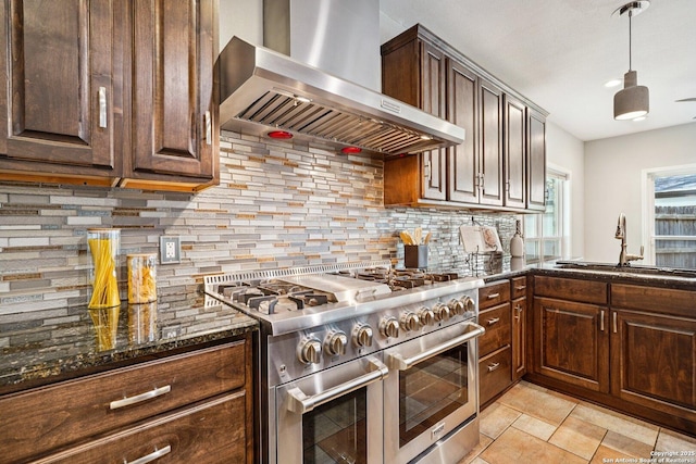 1159 Bluff Frst, San Antonio, TX 78248 - kitchen featuring range with two ovens, wall chimney exhaust hood, dark stone countertops, and backsplash