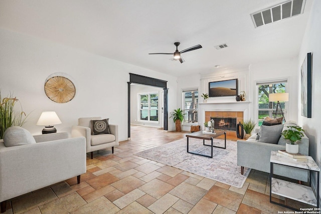 1159 Bluff Frst, San Antonio, TX 78248 - living area featuring plenty of natural light, a ceiling fan, a tiled fireplace, and stone tile floors