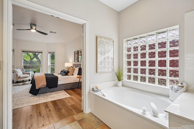 1159 Bluff Frst, San Antonio, TX 78248 - bathroom with ensuite bath, a garden tub, a ceiling fan, and wood finished floors