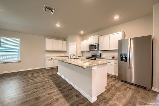 3008 Pemberton Post, San Antonio, TX 78245 - kitchen with appliances with stainless steel finishes, decorative backsplash, an island with sink, white cabinets, and dark wood-style flooring