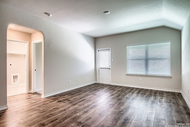 3008 Pemberton Post, San Antonio, TX 78245 - empty room with dark wood-style flooring, arched walkways, a textured ceiling, a smoke detector, and vaulted ceiling