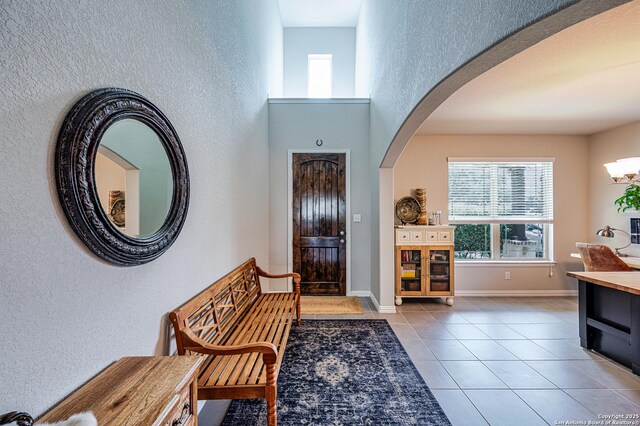 13942 Evelina, San Antonio, TX 78253 - foyer with arched walkways, healthy amount of natural light, light tile patterned floors, a textured wall, and a towering ceiling