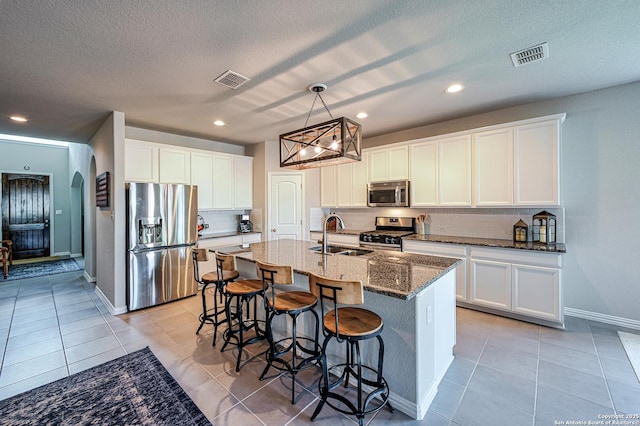 13942 Evelina, San Antonio, TX 78253 - kitchen featuring stainless steel appliances, decorative backsplash, light tile patterned flooring, dark stone counters, and a breakfast bar