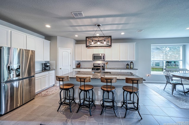 13942 Evelina, San Antonio, TX 78253 - kitchen with stainless steel appliances, decorative backsplash, an island with sink, white cabinetry, and recessed lighting
