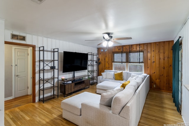 450 Pamela, San Antonio, TX 78223 - living area with a ceiling fan, light wood finished floors, and wood walls