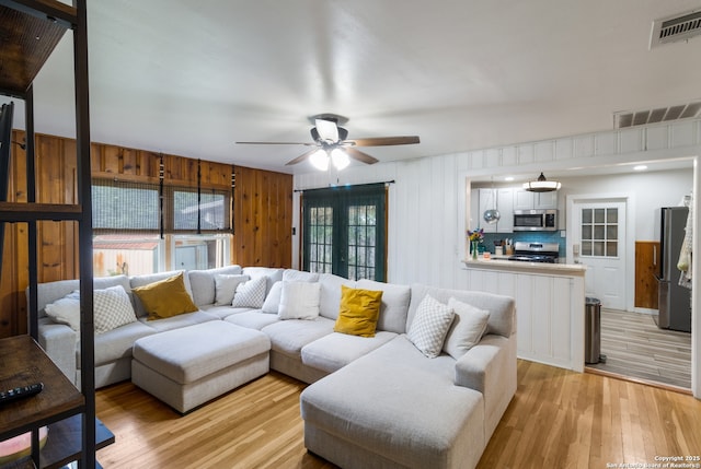 450 Pamela, San Antonio, TX 78223 - living area featuring a ceiling fan, light wood-style flooring, and wood walls