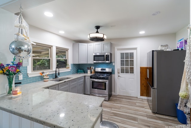 450 Pamela, San Antonio, TX 78223 - kitchen with appliances with stainless steel finishes, a peninsula, light stone countertops, backsplash, and recessed lighting